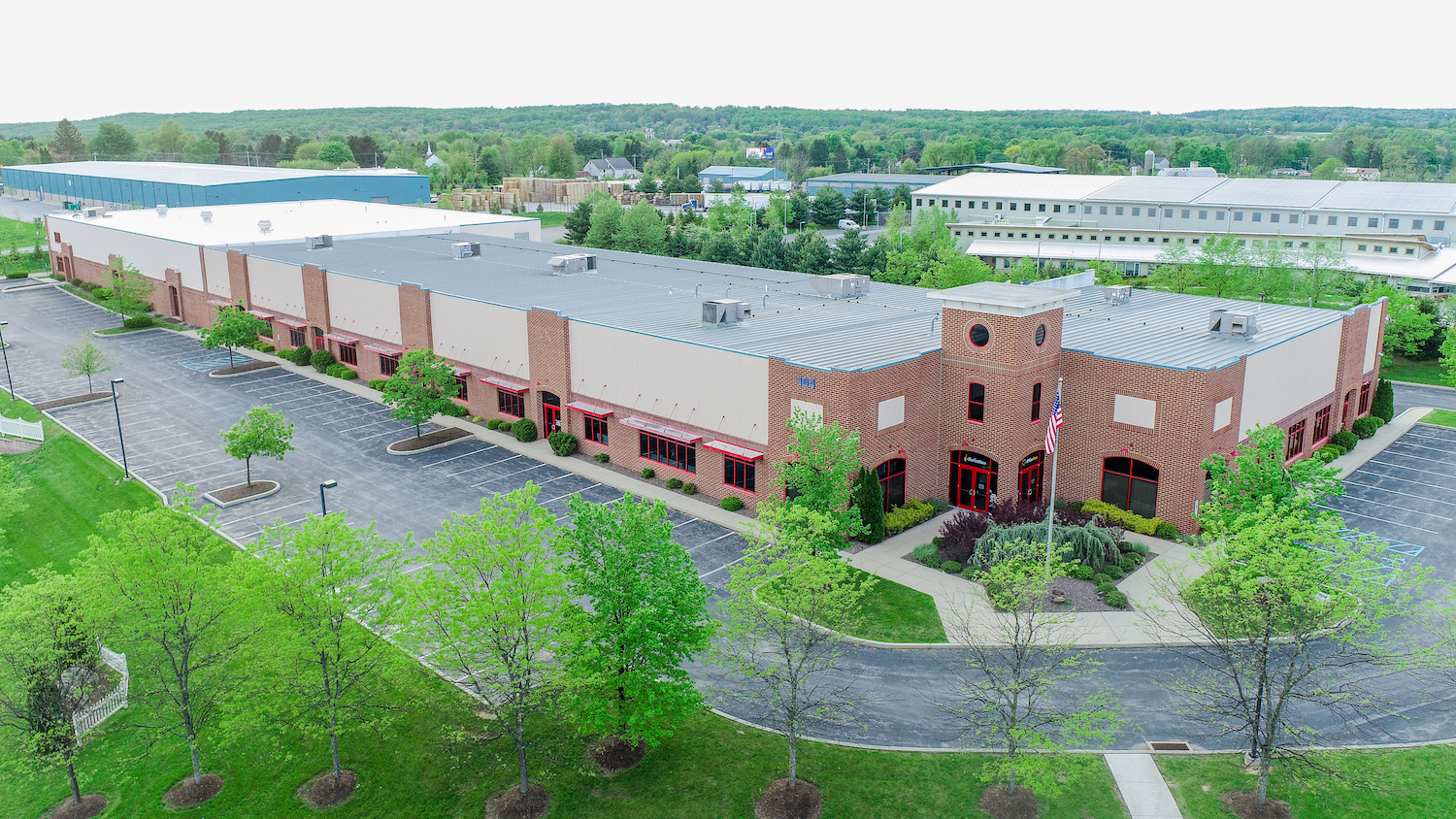 Brick large industrial building with green landscape in industrial complex